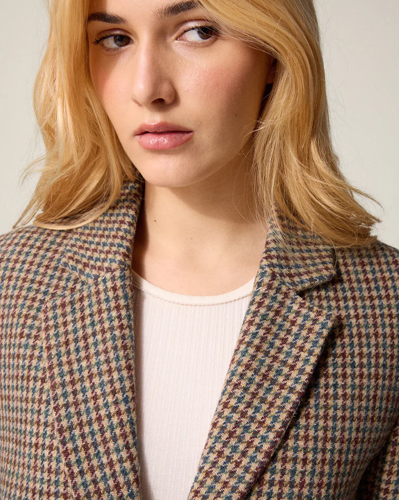 Klasyczna, jednorzędowa, wełniana marynarka w pepitkę Jacques Rouje o prostym kroju i długości za biodra. Zapinana na dwa guziki imitujące poroże. Marynarka ma klapy i trójkątny dekolt. Posiada dwie, przednie kieszenie z klapkami, niewielkie rozcięcie z tyłu i podszewkę