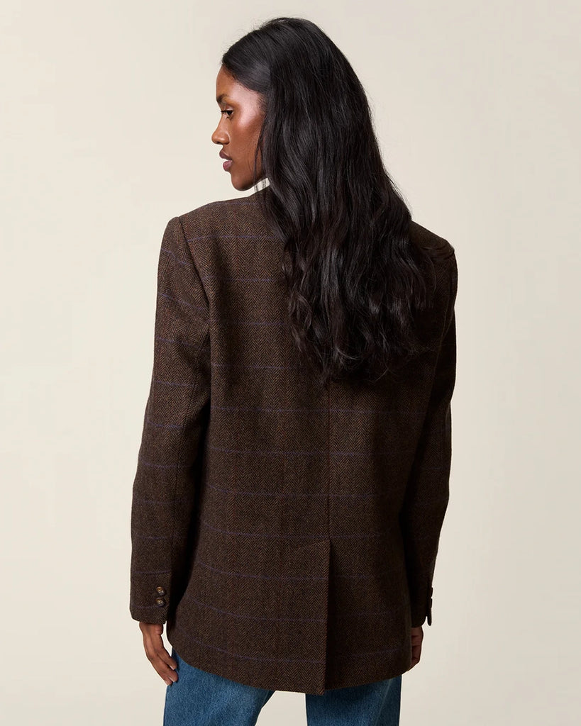 Klasyczna, dwurzędowa marynarka w kratkę z wełną Marcel Rouje. Posiada prosty krój, dekolt w kształcie litery V i klapy. Marynarka ma dwie, przednie kieszenie i rozcięcie z tyłu oraz podszewkę. Zapinana na guziki imitujące poroże.