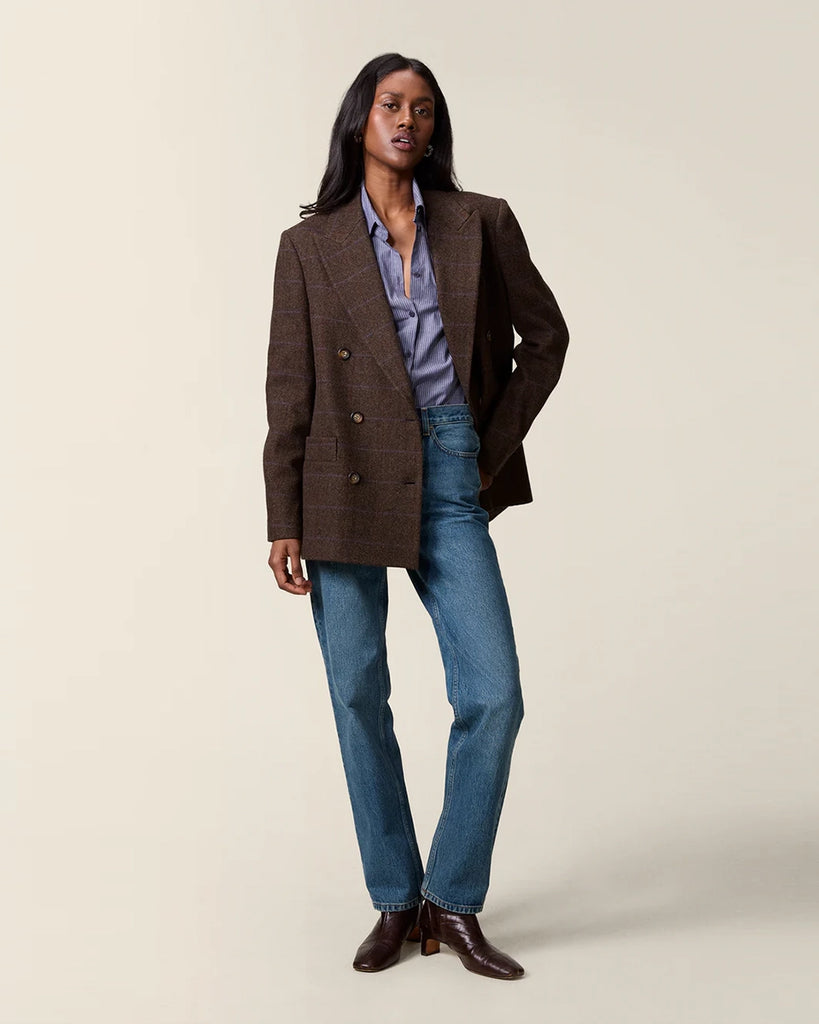 Klasyczna, dwurzędowa marynarka w kratkę z wełną Marcel Rouje. Posiada prosty krój, dekolt w kształcie litery V i klapy. Marynarka ma dwie, przednie kieszenie i rozcięcie z tyłu oraz podszewkę. Zapinana na guziki imitujące poroże.