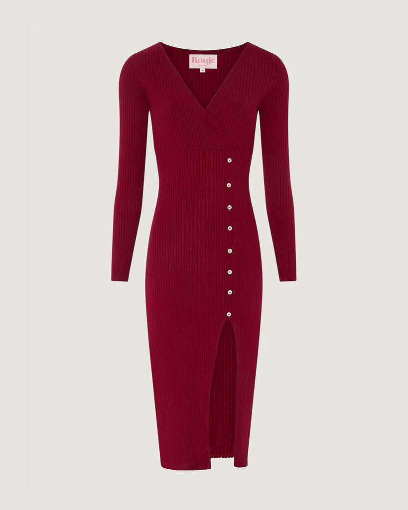 Dzianinowa sukienka midi Mila Rouje z głębokim, trójkątnym dekoltem i długimi, wąskimi rękawami. Z boku posiada guziki z masy perłowej. U dołu ma głębokie rozcięcie. Sukienka posiada przylegający fason, który pięknie eksponuje sylwetkę oraz długość do połowy łydki
