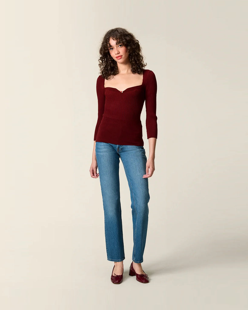 Dzianinowa bluzka Nesta Rouje o dopasowanym fasonie pięknie podkreślającym sylwetkę. Posiada efektowny, sercowy dekolt z niewielką, uroczą różyczką przy piersiach oraz wąskie rękawy 3/4.