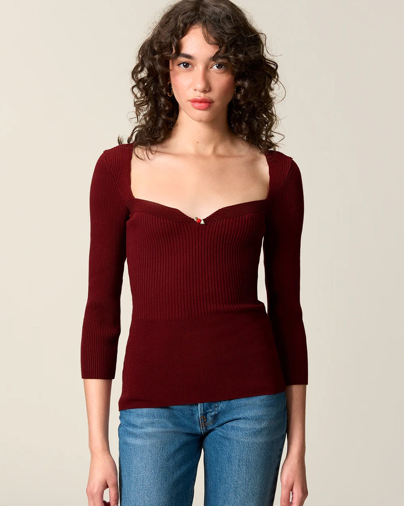 Dzianinowa bluzka Nesta Rouje o dopasowanym fasonie pięknie podkreślającym sylwetkę. Posiada efektowny, sercowy dekolt z niewielką, uroczą różyczką przy piersiach oraz wąskie rękawy 3/4.