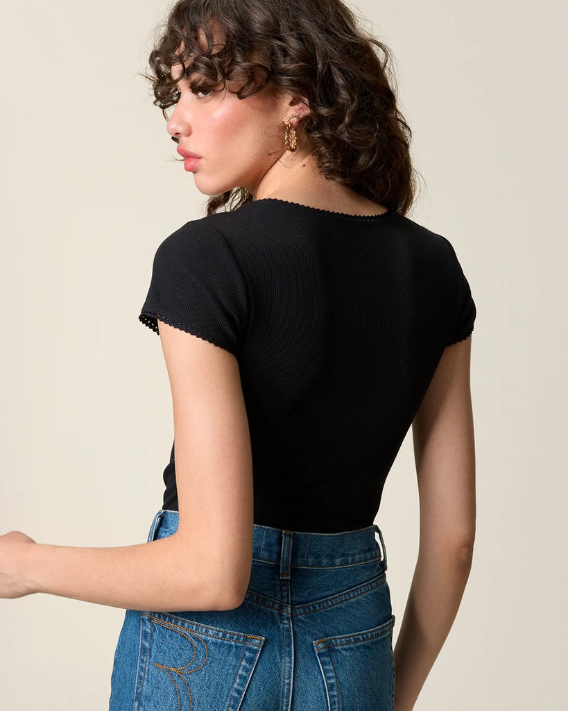 Dopasowany, czarny t-shirt Siam Rouje z głębokim okrągłym dekoltem i krótkim rękawem. Wykończony delikatną koronką. Wykonany z lekko elastycznej, bawełnianej tkaniny o prążkowanej fakturze. 