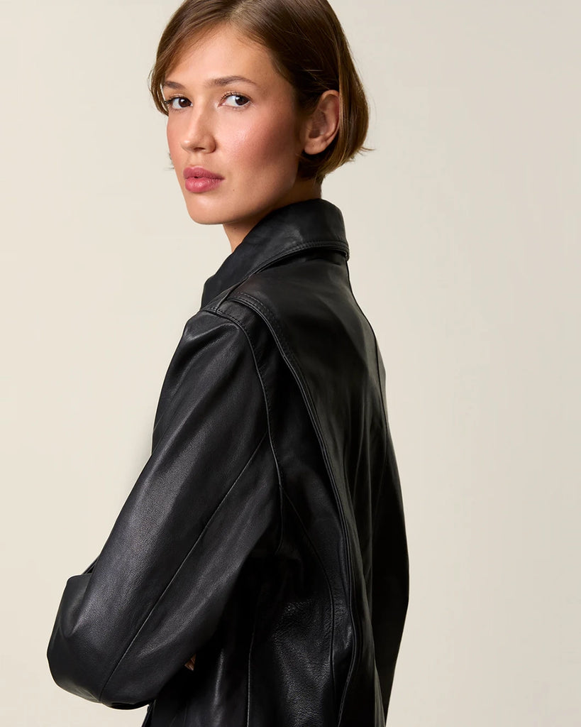 Czarna, krótka kurtka skórzana Stan Rouje o prostym kroju. Posiada kołnierzyk i dwie, boczne kieszenie. Z przodu i przy mankietach rękawów zapinana na guziki. Kurtka ma podszewkę we wzór w grochy.