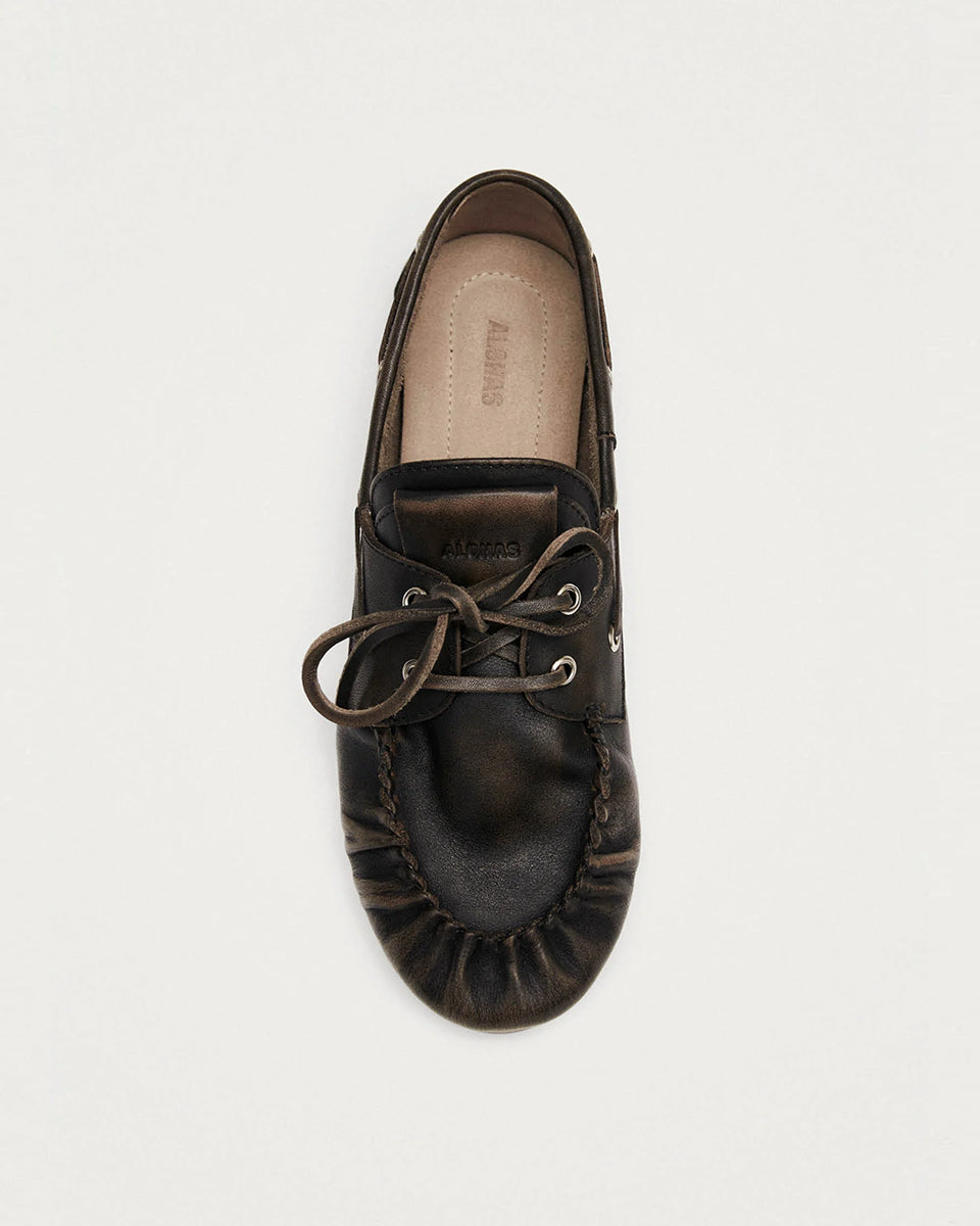Brązowe, skórzane mokasyny Rowan Vintage Brown Leather marki ALOHAS w stylu butów żeglarskich z klasycznym marszczonym przodem. Posiadają charakterystyczne wiązanie wokół i sznurowanie uzupełnione o metalowe przelotki. Wykonane z wysokiej jakości szczotkowanej skóry, wyróżniają się fakturowanym wykończeniem. To ponadczasowy wybór dla osób ceniących swobodną elegancję.

-100% skóra pochodząca ze zrównoważonych i odpowiedzialnych źródeł&nbsp;

-Zaprojektowane w Barcelonie&nbsp;

-Jeśli twoja stopa wypada międ