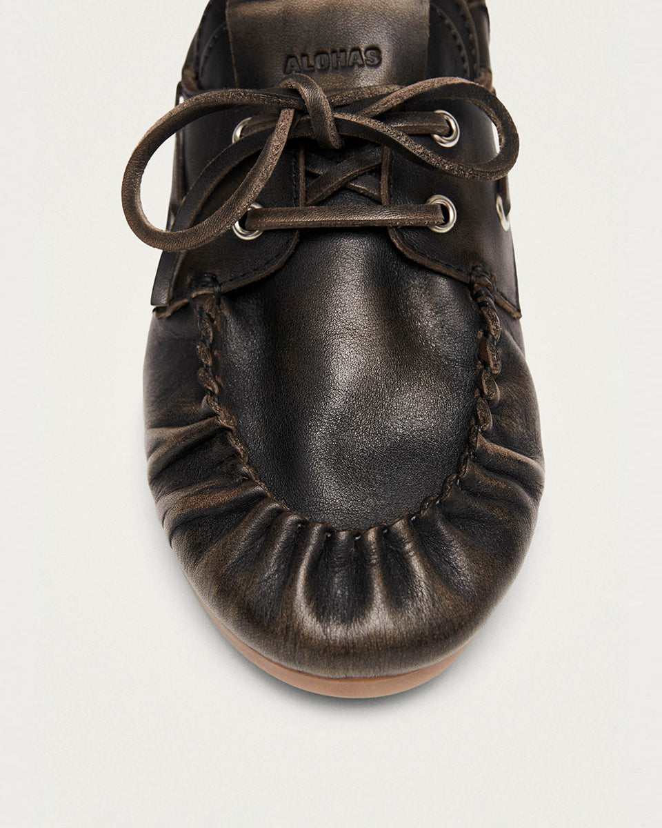Brązowe, skórzane mokasyny Rowan Vintage Brown Leather marki ALOHAS w stylu butów żeglarskich z klasycznym marszczonym przodem. Posiadają charakterystyczne wiązanie wokół i sznurowanie uzupełnione o metalowe przelotki. Wykonane z wysokiej jakości szczotkowanej skóry, wyróżniają się fakturowanym wykończeniem. To ponadczasowy wybór dla osób ceniących swobodną elegancję.

-100% skóra pochodząca ze zrównoważonych i odpowiedzialnych źródeł&nbsp;

-Zaprojektowane w Barcelonie&nbsp;

-Jeśli twoja stopa wypada międ
