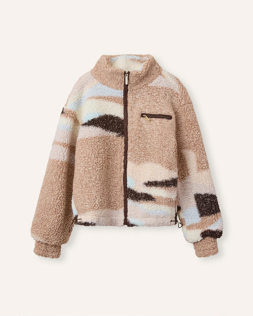 Kurtka polarowa marki HELMSTEDT Safiya Fleece z gradientem kolorów, które przechodząc miedzy sobą tworzą efektowny wzór. Zapinana jest z przodu na brązowy zamek z logo HELMSTEDT. Posiada ściągacz na dole, kieszenie boczne oraz kieszeń na piersi po prawej stronie. Rękawy są szerokie, zakończone przeszyciem utrzymującym kształt. Kurtka jest stylowym elementem jesiennych stylizacji.&nbsp;