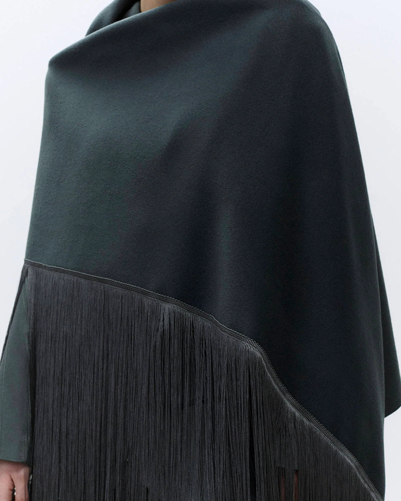 Obszerny szal Sciarpa Choco w kolorze brązowym wykonany w 100% z wełny. Zakończony jest długimi frędzlami w pasującym kolorze.
