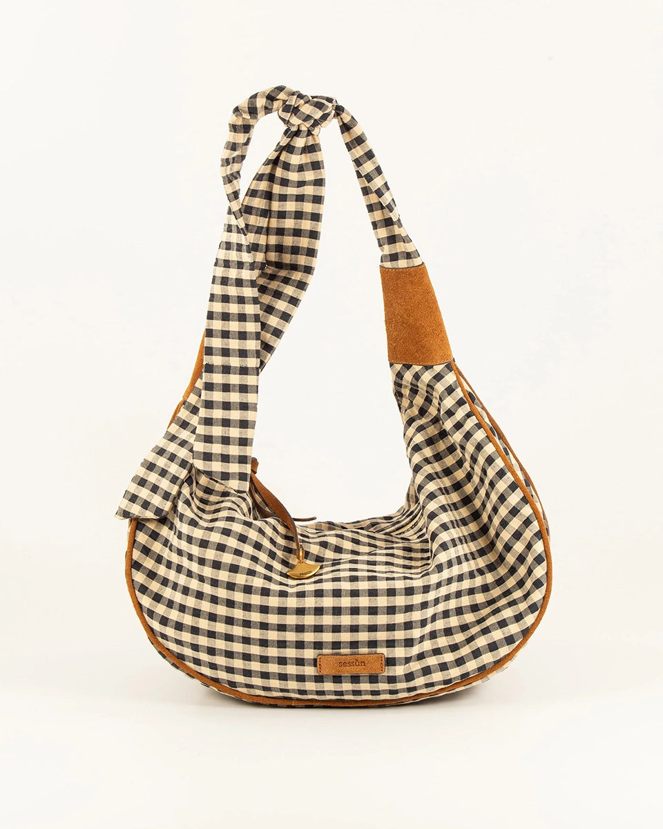 Miękka, casualowa torebka o średniej wielkości Minilango Sessun w kratkę z wiązaną rączką o długości wygodnej do zawieszenia na ramieniu i przewieszenia przez ramię. Zapinana na zamek błyskawiczny. Wykończona zamszowymi detalami. Z przodu posiada niewielką naszywkę z logo marki. Przy zamku znajduje się skórzany rzemyk zakończony ozdobną, brązową zawieszką. Wewnątrz obszyta bawełnianą podszewką. W środku torebki znajduje się niewielka kieszonka na najważniejsze drobiazgi. -Regulowany pasek -100% bawełna -Baw