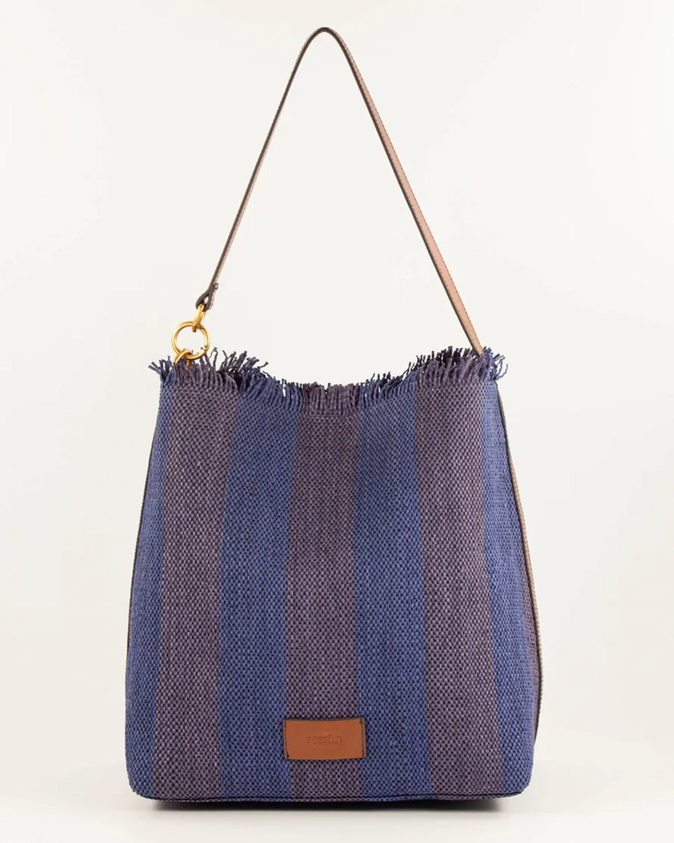 Letnia, pleciona torba w pasy w typie shopper Vita Mia Sessun. U góry wykończona frędzlami. Torba posiada skórzany pasek do wygodnego zawieszenia na ramieniu oraz niewielką naszywkę z logo marki na froncie. Wewnątrz torebki znajduje się niewielka, zapinana na zamek błyskawiczny kieszonka na najważniejsze drobiazgi.