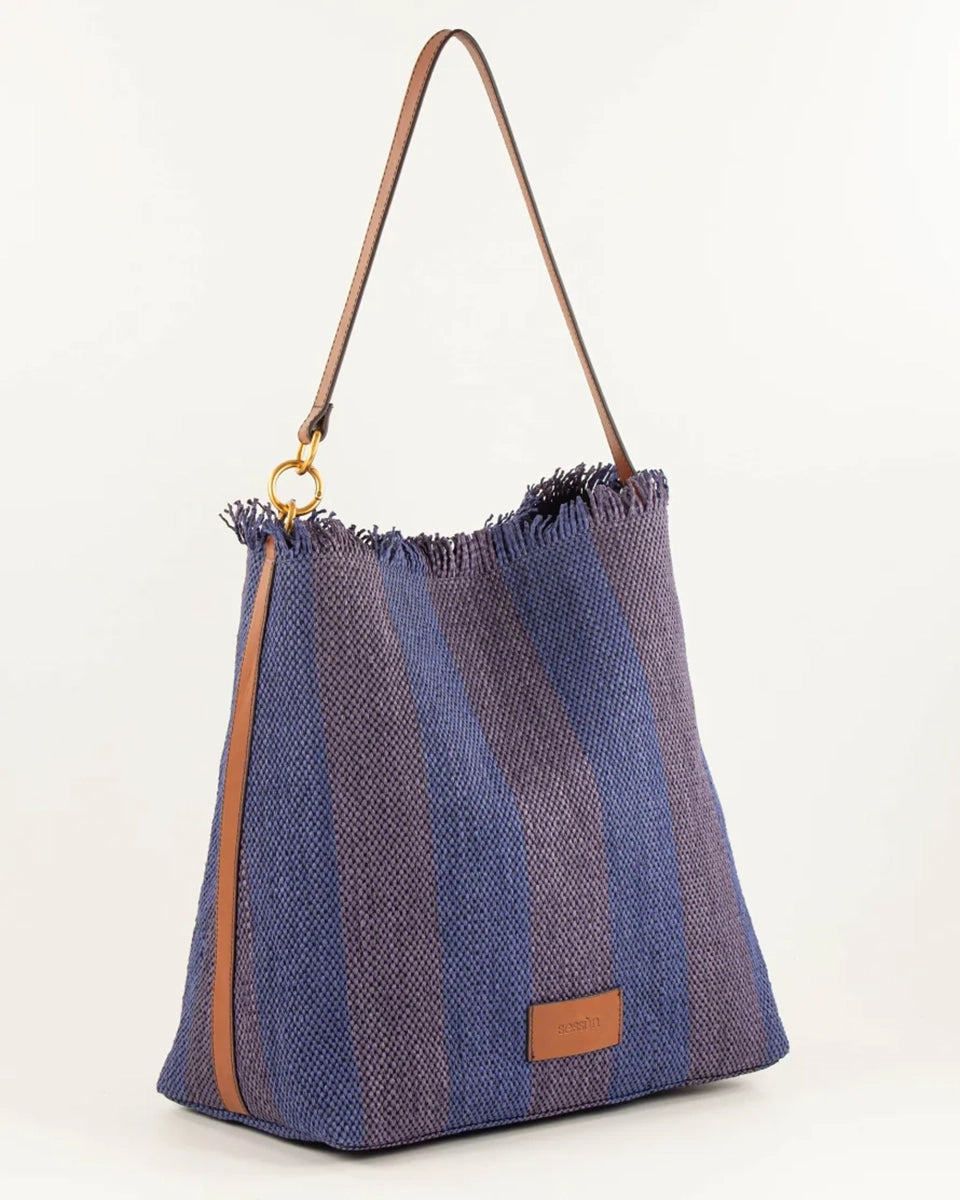 Letnia, pleciona torba w pasy w typie shopper Vita Mia Sessun. U góry wykończona frędzlami. Torba posiada skórzany pasek do wygodnego zawieszenia na ramieniu oraz niewielką naszywkę z logo marki na froncie. Wewnątrz torebki znajduje się niewielka, zapinana na zamek błyskawiczny kieszonka na najważniejsze drobiazgi.