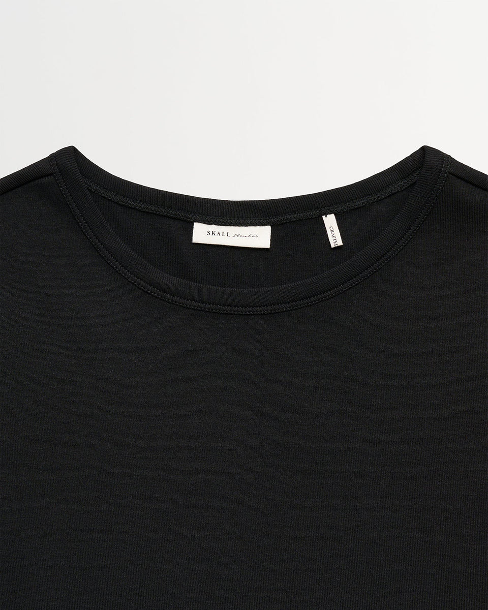 Minimalistyczny, czarny, bawełniany longsleeve Seventies O-neck SKALL z okrągłym dekoltem i wąskimi, długimi rękawami. Posiada przylegający do ciała fason i delikatną, gładką fakturę. Wykonany z organicznej i bardzo przyjemnej dla skóry bawełny. To bluzka idealna do warstwowych stylizacji.&nbsp;

-Przylegający fason

-100% bawełna organiczna

-Zamów longsleeve w swoim normalnym rozmiarze