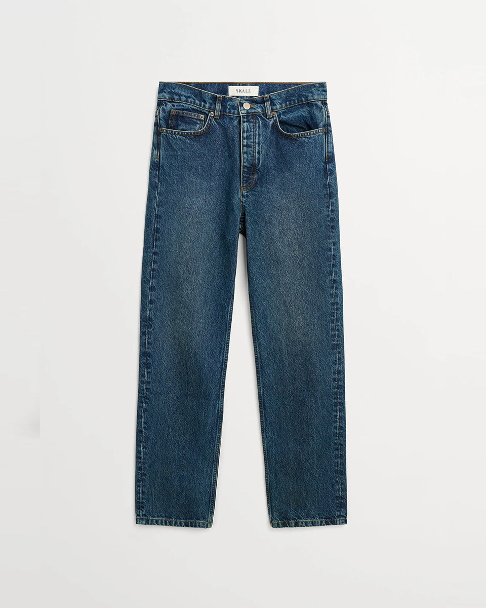 Klasyczne jeansy Sharon Straight Washed Dark Blue marki SKALL z wysokim stanem, wąskimi, prostymi nogawkami i klasycznymi, jeansowymi detalami. Mają pięć kieszeni, szlufki na pasek oraz haftowane logo marki z tyłu w pasie. Wykonane w 100% z certyfikowanej bawełny organicznej.&nbsp;

-Wysoki stan

-Wąskie, proste nogawki

-100% bawełna organiczna