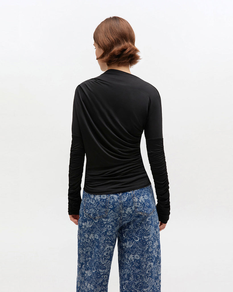 Czarny, taliowany top 4393 Shiny Jersey Black marki GANNI z asymetrycznym dekoltem i marszczeniami przy rękawach oraz na całej długości. Zestaw go z elegancką spódnicą lub jeansami, aby uzyskać bardziej codzienny look.