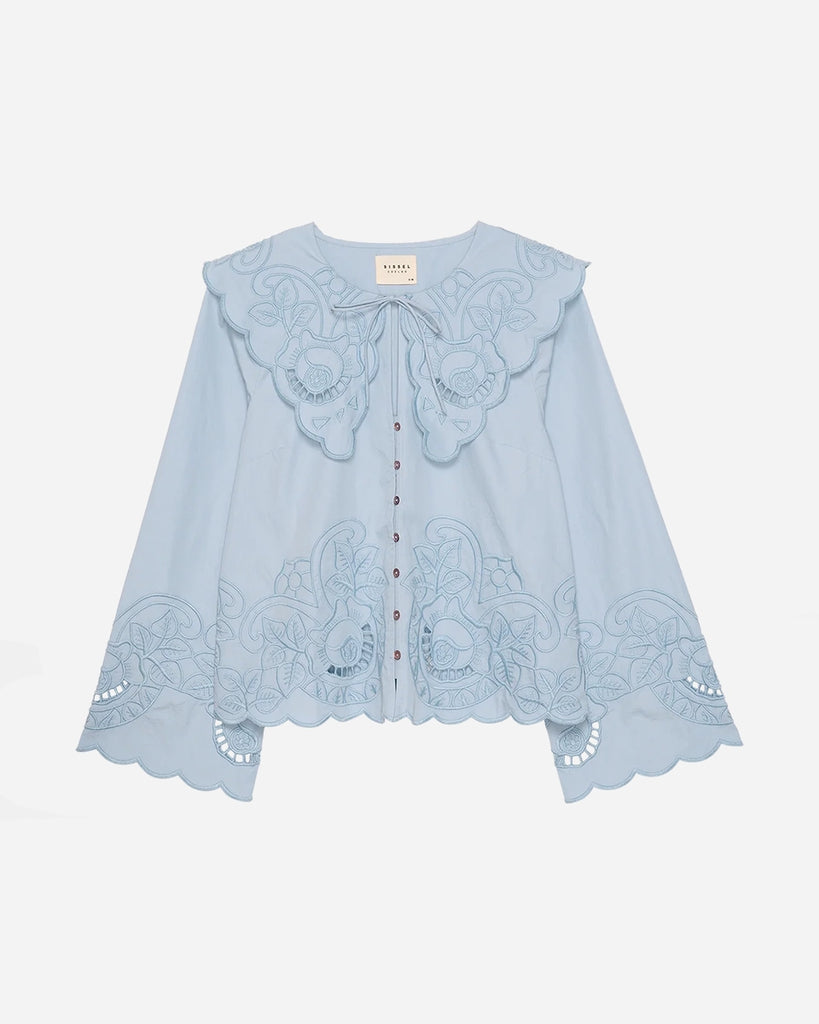 Romantyczna, koszulowa bluzka Cameron SISSEL EDELBO z dużym, efektownym kołnierzem i długim, rozszerzanym rękawem. Wiązana pod szyją. Zapinana na guziki z masy perłowej i haftki