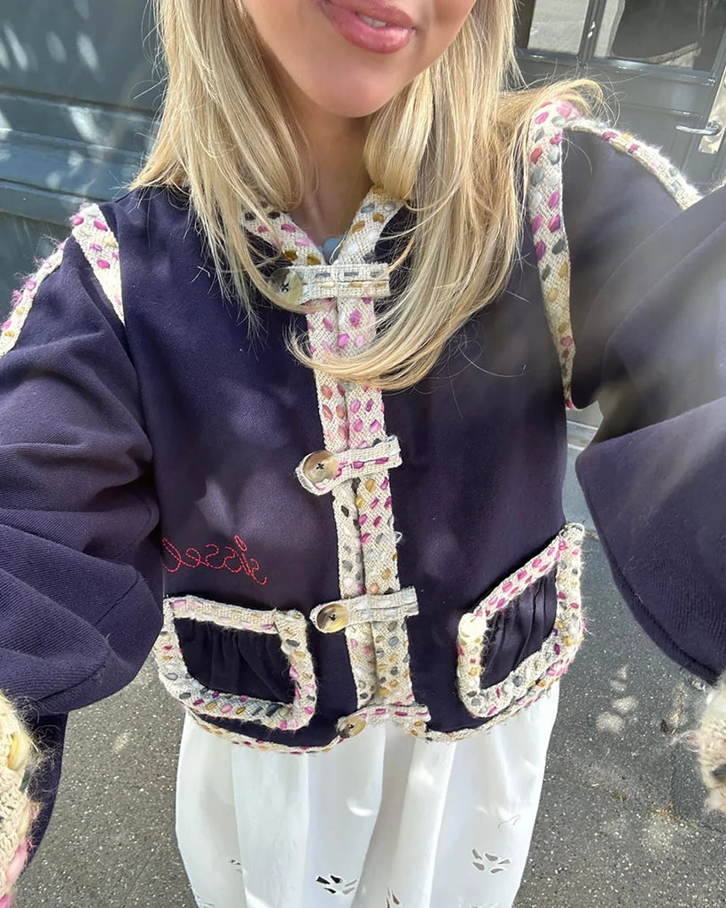 Cienka, krótka kurtka Como SISSEL EDELBO o pudełkowym kroju z długimi, balonowymi rękawami. Zapinana na duże guziki i haftki. Wykończona zaokrąglonymi rogami i grubą lamówką z tkaniny boucle