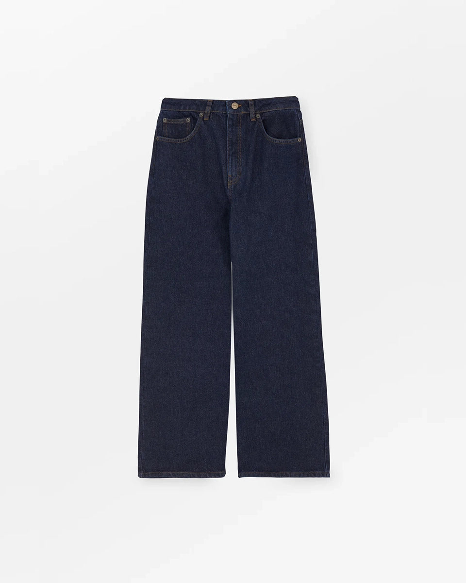 Luźne jeansy Willow Indigo Blue SKALL z obniżonym stanem i szerokimi, prostymi nogawkami. Posiadają kieszenie, szlufki na pasek i haftowane logo z tyłu w pasie. Jeansy maja standardową długość. Wykonane ze sztywnego denimu z bawełny organicznej.