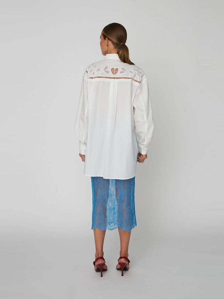 Oversizowa, biała koszula Embroidery Anglaise z krótkim dekorowana pięknym, ażurowym haftem angielskim. Posiada kołnierzyk opadające ramiona i luźne, długie rękawy wykończone mankietami. Zapinana na guziki.