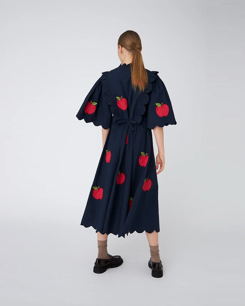 Bawełniana sukienka midi EMBROIDERED STELLA NOVA z uroczymi naszywkami w kształcie jabłek. Posiada okrągły dekolt pod szyję i szerokie, krótkie rękawy o długości do łokci. Sukienka jest zwężana i przylegająca w talii, co pięknie podkreśla sylwetkę.