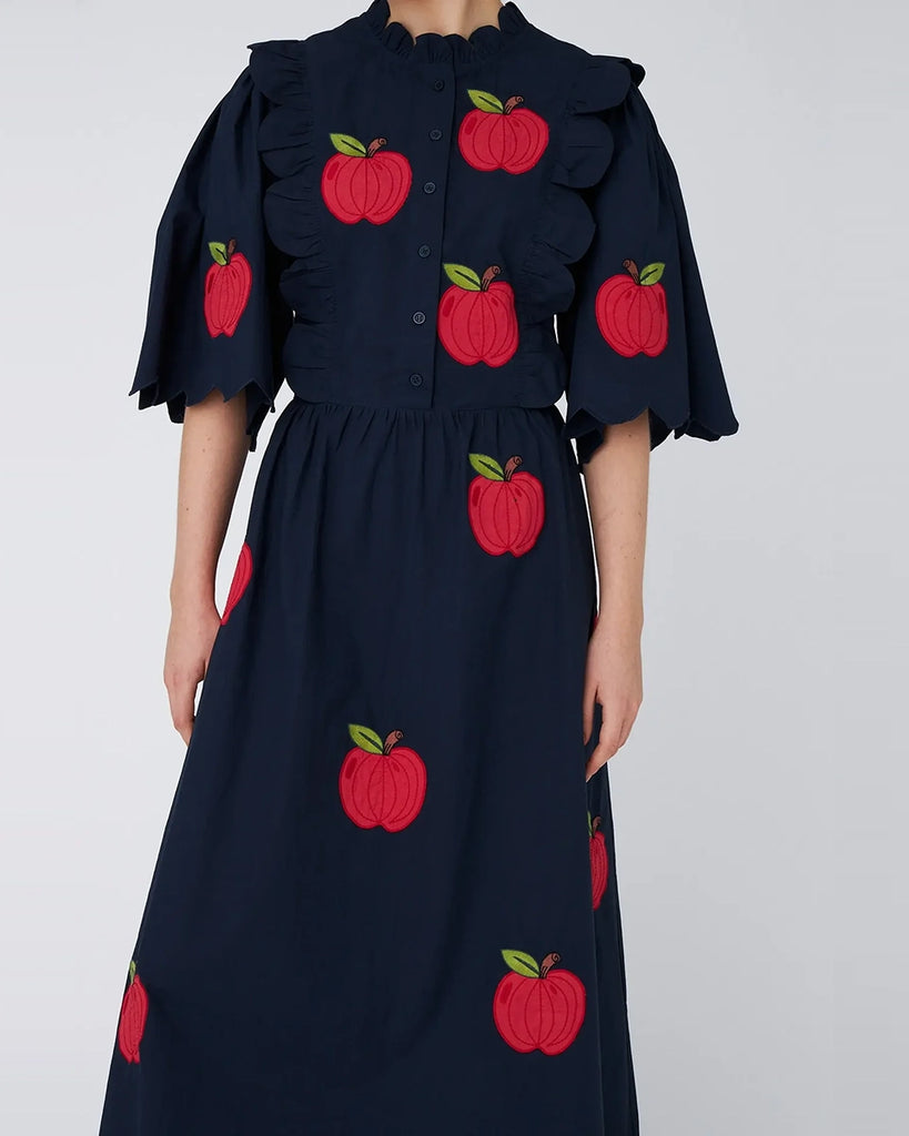 Bawełniana sukienka midi EMBROIDERED STELLA NOVA z uroczymi naszywkami w kształcie jabłek. Posiada okrągły dekolt pod szyję i szerokie, krótkie rękawy o długości do łokci. Sukienka jest zwężana i przylegająca w talii, co pięknie podkreśla sylwetkę.