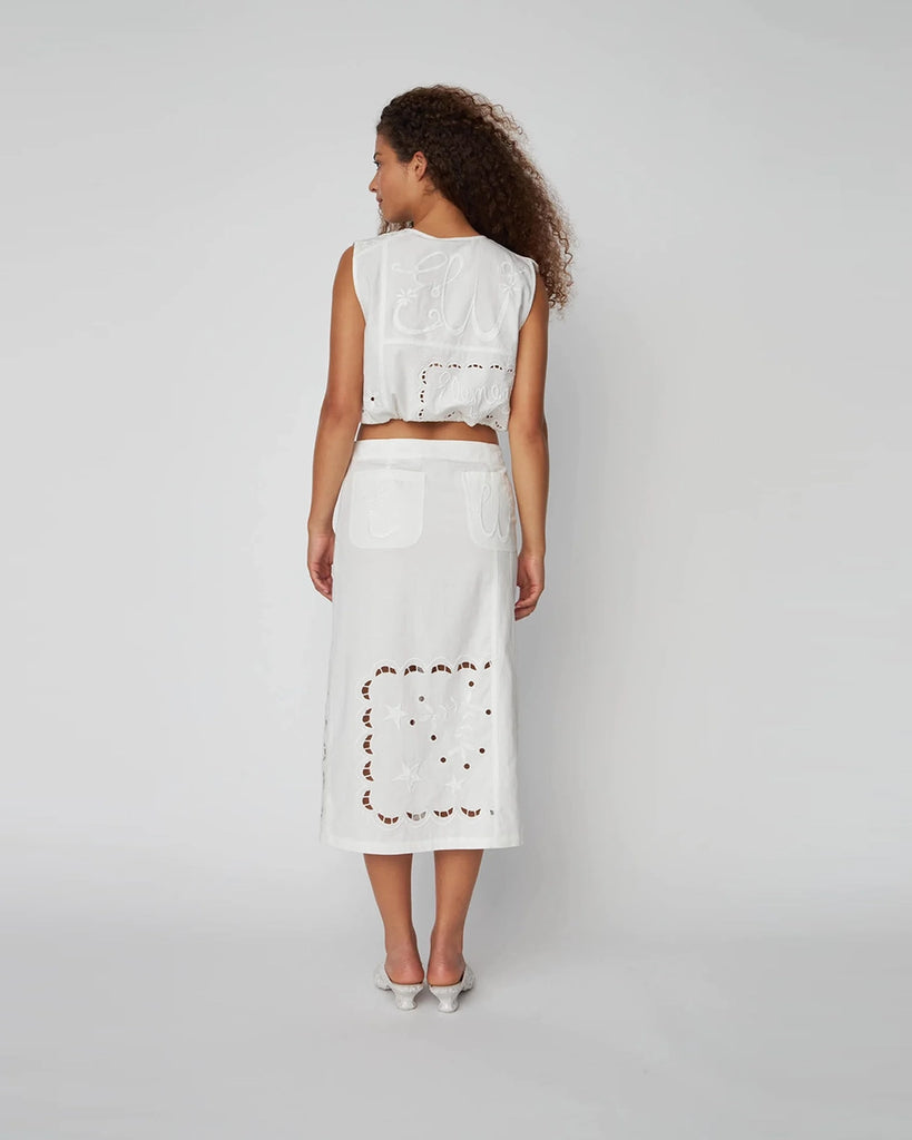 Bawełniany, krótki, biały top Elements Embroidered z dekoltem w serek z muszelkowym wykończeniem. Bluzka ma luźny fason i prosty kroj. Wykonana jest z bawełnianej tkaniny z uroczymi haftami. 