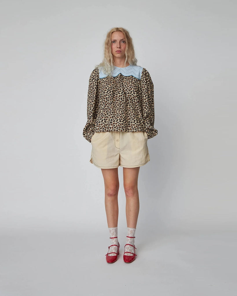 Luźna bluzka w panterę Leopard Blouse STELLA NOVA z szerokimi, długimi rękawami zakończonymi, elastycznymi gumkami przy nadgarstkach. Bluzka ma okrągły dekolt i kontrastowy kołnierz. Na plecach posiada trójkątne wycięcie i wiązanie przy szyi. 