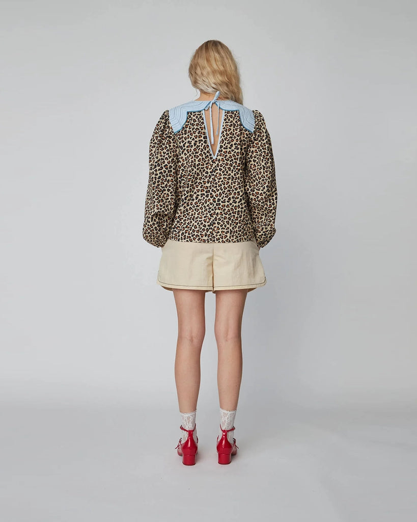 Luźna bluzka w panterę Leopard Blouse STELLA NOVA z szerokimi, długimi rękawami zakończonymi, elastycznymi gumkami przy nadgarstkach. Bluzka ma okrągły dekolt i kontrastowy kołnierz. Na plecach posiada trójkątne wycięcie i wiązanie przy szyi. 