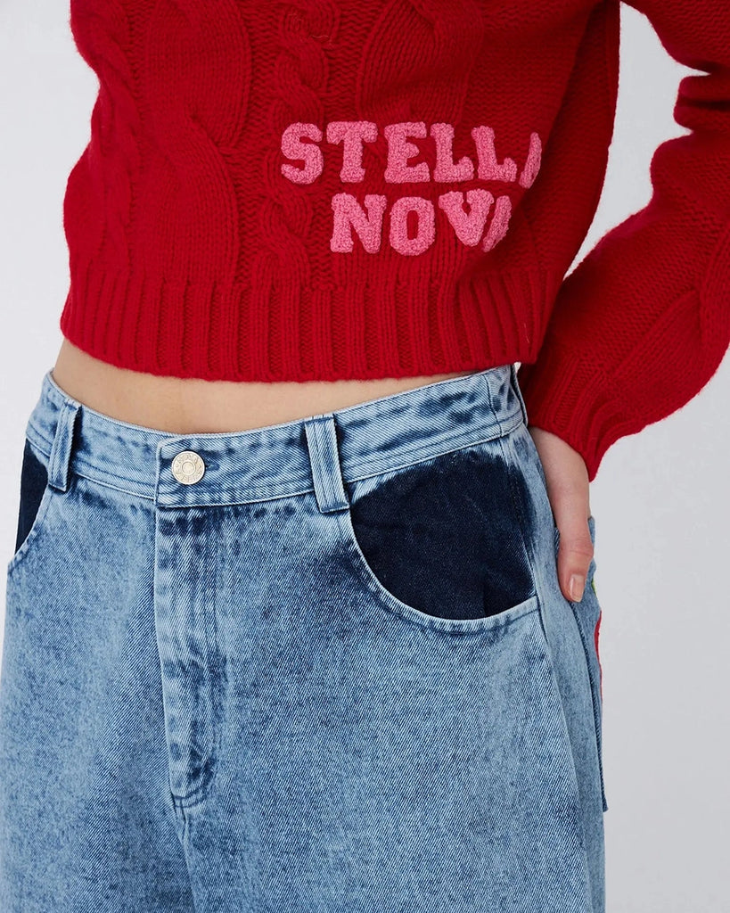 Luźne, jeansowe szorty STELLA NOVA z niskim stanem i szeroką nogawką o długości za kolana. Wykonane z jeansu z efektem "sprania". Szorty mają dwie, przednie kieszenie ufarbowane na ciemnogranatowy kolor. Na lewej, tylnej kieszeni spodnie posiadają naszywkę z uroczym motywem jabłka.