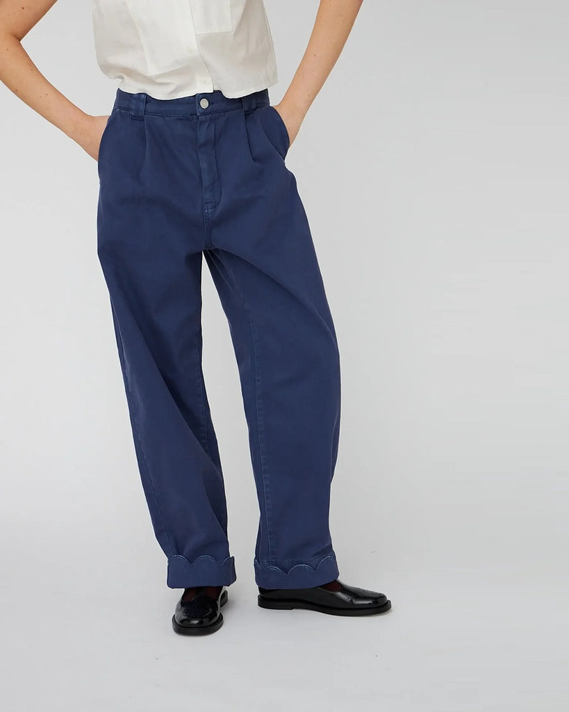 Luźne, granatowe jeansy STELLA NOVA z niskim stanem i szeroką, długą, lekko zwężaną u dołu nogawką z zakładkami. Spodnie mają dwie boczne i dwie tylne kieszenie. U dołu wywijane i wykończone muszelkowo. 