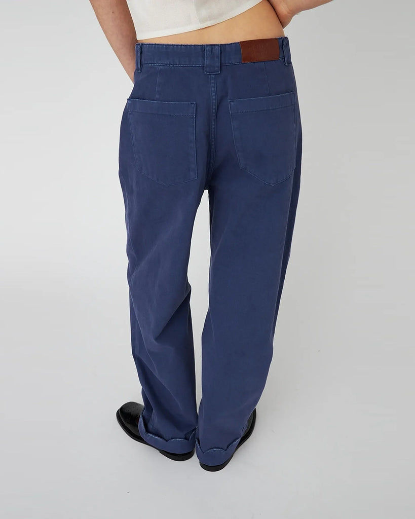 Luźne, granatowe jeansy STELLA NOVA z niskim stanem i szeroką, długą, lekko zwężaną u dołu nogawką z zakładkami. Spodnie mają dwie boczne i dwie tylne kieszenie. U dołu wywijane i wykończone muszelkowo. 