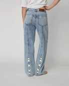 Luźne, niebieskie jeansy Moon Washed Denim STELLA NOVA z wysokim stanem i prostą, szeroką nogawką z przeszyciami. Z tyłu, u dołu nogawek posiadają oryginalne, plecione elementy.
