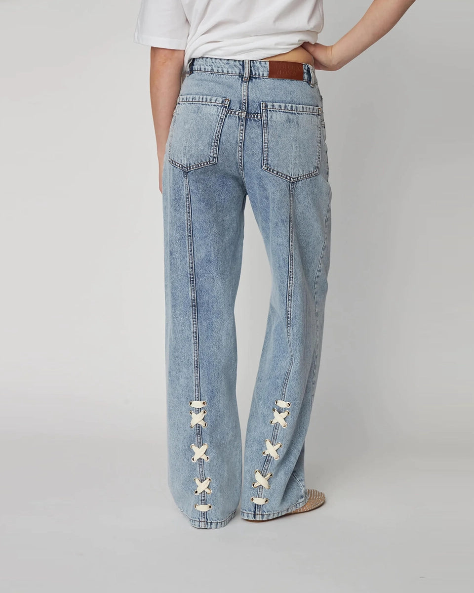 Luźne, niebieskie jeansy Moon Washed Denim STELLA NOVA z wysokim stanem i prostą, szeroką nogawką z przeszyciami. Z tyłu, u dołu nogawek posiadają oryginalne, plecione elementy.