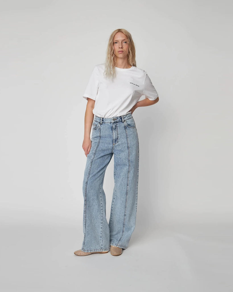 Luźne, niebieskie jeansy Moon Washed Denim STELLA NOVA z wysokim stanem i prostą, szeroką nogawką z przeszyciami. Z tyłu, u dołu nogawek posiadają oryginalne, plecione elementy.