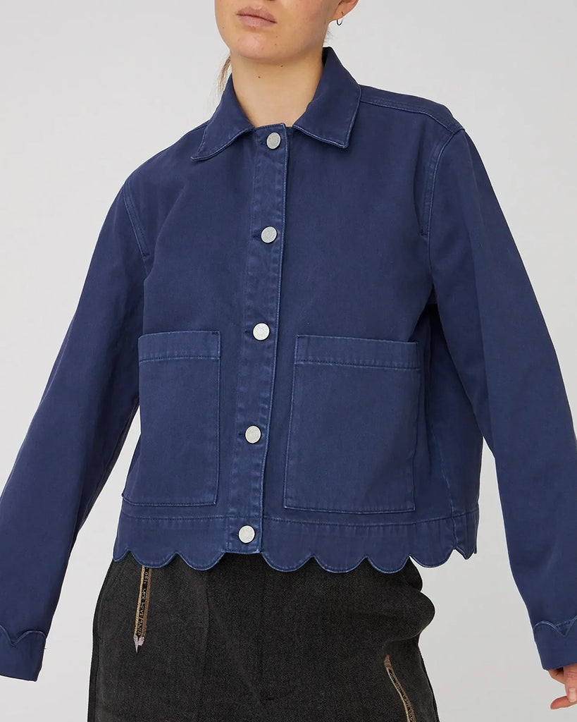 Jeansowa, luźna koszula STELLA NOVA z rozszerzanymi, wywijanymi rękawami. Posiada kołnierzyk i dwie, duże, przednie kieszenie. Zapinana na kontrastowe, srebrne guziki. Koszula na rękawach i u dołu wykończona jest muszelkowo.