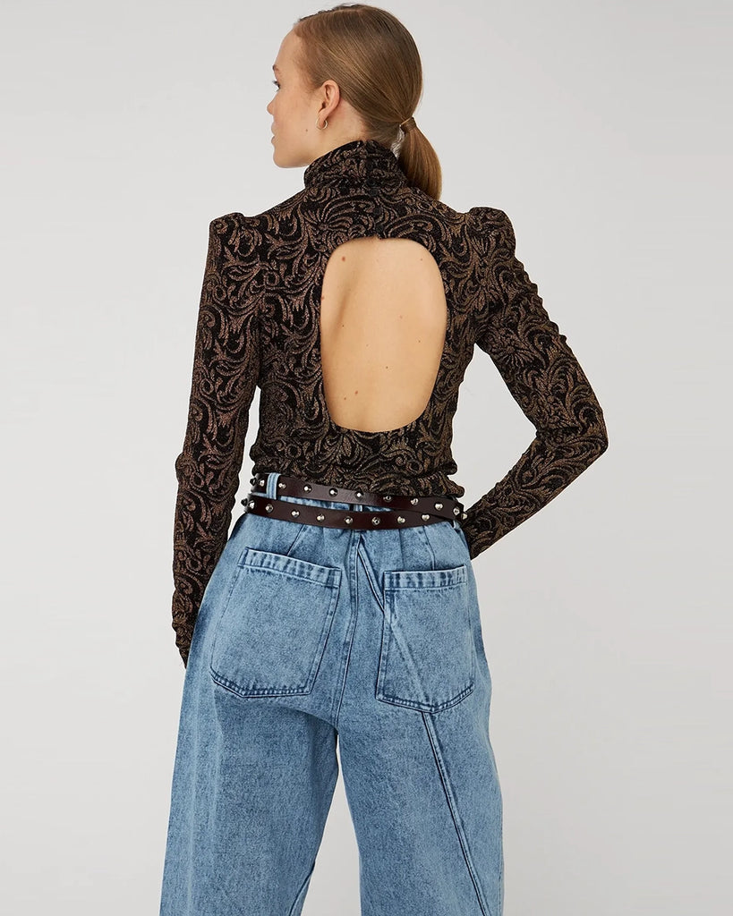 Żakardowa bluzka STELLA NOVA z bufkami i długimi, wąskimi rękawami. Posiada wysoki dekolt z golfem. Bluzka ma z tyłu duże, efektowne wycięcie eksponujące plecy. Wykonana z elastycznej tkaniny z metalicznym ornamentem.