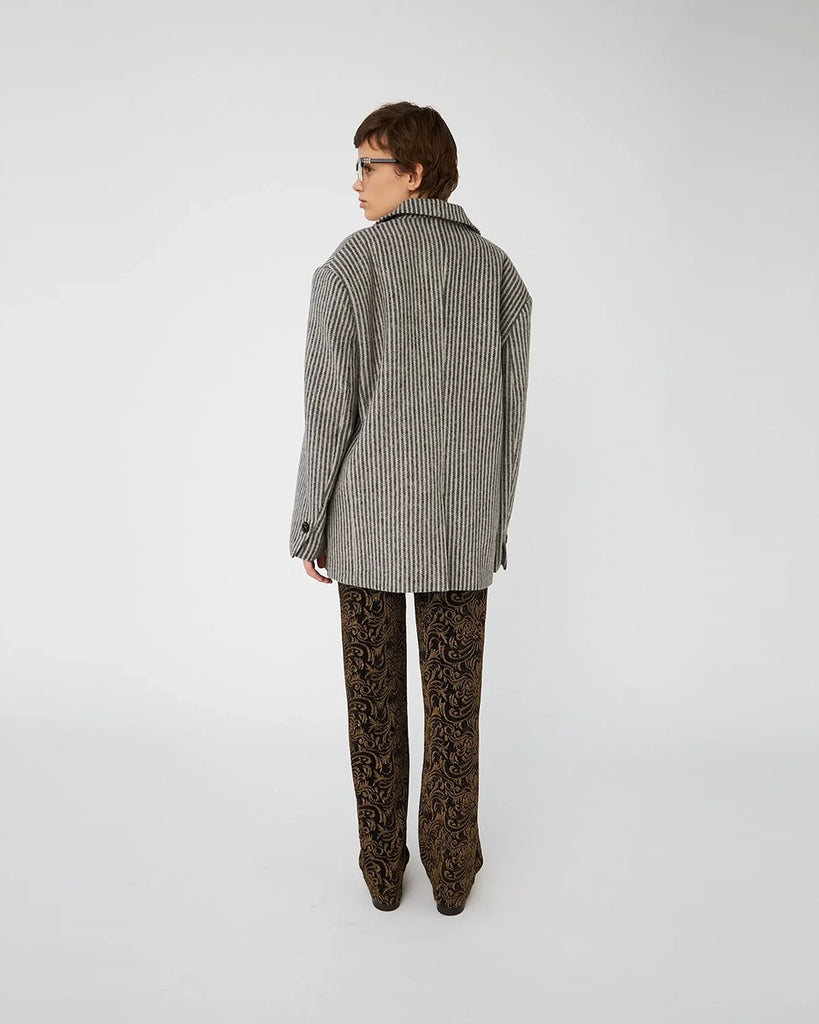 Mocno oversizowa, szara marynarka w cienkie prążki STELLA NOVA z szerokimi ramionami z poduszkami. Marynarka ma prosty krój. Jest zapinana na jeden guzik. Posiada podszewkę oraz dwie, przednie kieszenie. 