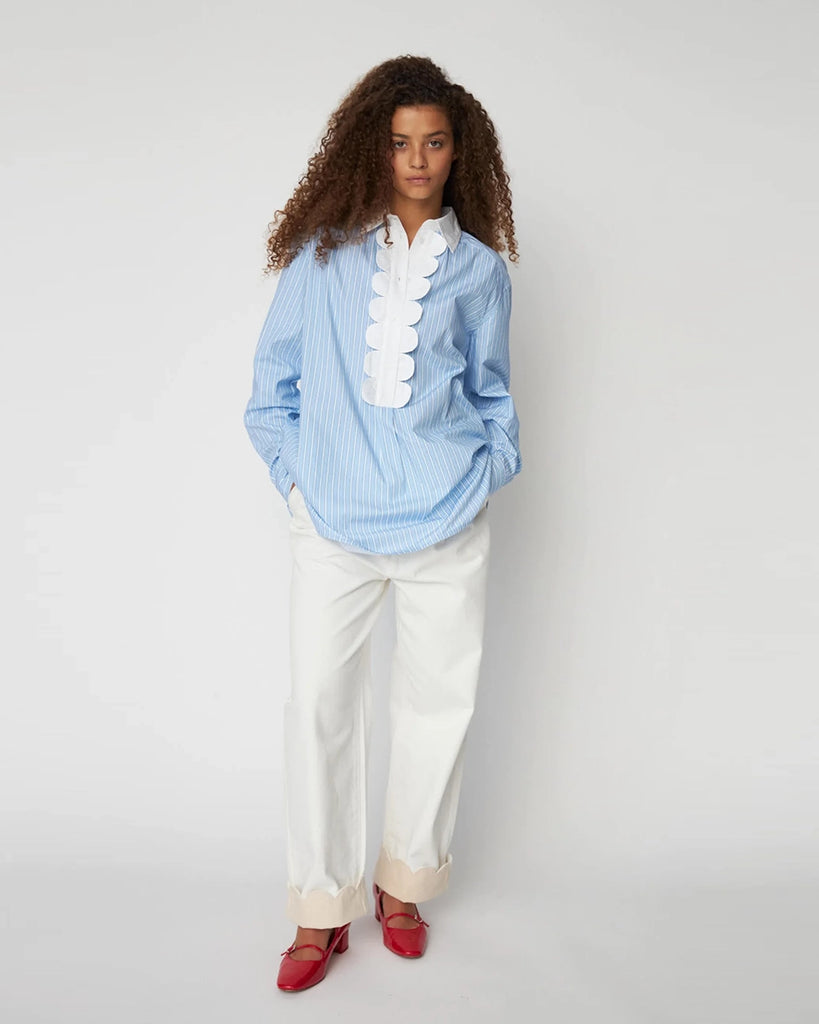 Oversizowa, niebieska koszula w cienkie paski Striped Shirt STELLA NOVA z kontrastowym kołnierzykiem i muszelkowym wykończeniem przy dekolcie. U góry zapinana na guziki.