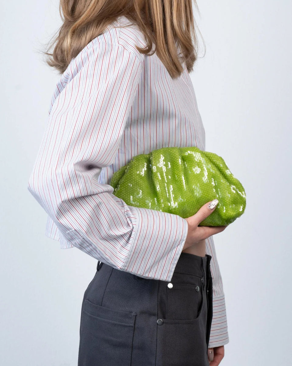 Torebka kopertówka Sequin Clutch Green SUI AVA o miękkiej powierzchni pokrytej połyskującymi cekinami. Jej elastyczny kształt nadaje jej swobodny, a zarazem elegancki wygląd. To idealny dodatek do Twojej stylizacji. Pomieści niezbędne drobiazgi, takie jak telefon, klucze i szminkę. Noś ją w dłoni jak elegancką kopertówkę.&nbsp;