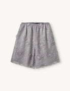 Szerokie, ażurowe, szaro-srebrzyste szorty Sydney Oyster marki The Garment w kształcie litery A. Wykończone w talii elastyczną gumką. Ozdobione są trójwymiarową koronką z wyrazistymi, wypukłymi aplikacjami w kształcie kwiatów. Długość sięga mniej więcej do polowy uda. U dołu brzeg nogawek jest wycięty 'w ząbki'.

-Swobodny krój typu A-line

-Gumka w talii

-Ozdobione koronką i kwiatami

-Zamów szorty w swoim normalnym rozmiarze