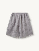 Szerokie, ażurowe, szaro-srebrzyste szorty Sydney Oyster marki The Garment w kształcie litery A. Wykończone w talii elastyczną gumką. Ozdobione są trójwymiarową koronką z wyrazistymi, wypukłymi aplikacjami w kształcie kwiatów. Długość sięga mniej więcej do polowy uda. U dołu brzeg nogawek jest wycięty 'w ząbki'.

-Swobodny krój typu A-line

-Gumka w talii

-Ozdobione koronką i kwiatami

-Zamów szorty w swoim normalnym rozmiarze