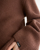 Luźny, brązowy sweter z golfem Synin Tiramisu Bellerose wykonany w 100% z kaszmiru. Posiada proste, szerokie rękawy z wywiniętymi mankietami i kołnierz typu funnel neck. Ma swobodny, lekko luźny krój oraz wyraźną, prążkowaną strukturę materiału. Wysoki, otulający golf dodaje mu szyku i doskonale sprawdza się w chłodniejsze dni, tworząc stylową kompozycję z ciemnymi spodniami.

-Golf

-Długie, szerokie rękawy&nbsp;

-100% kaszmir