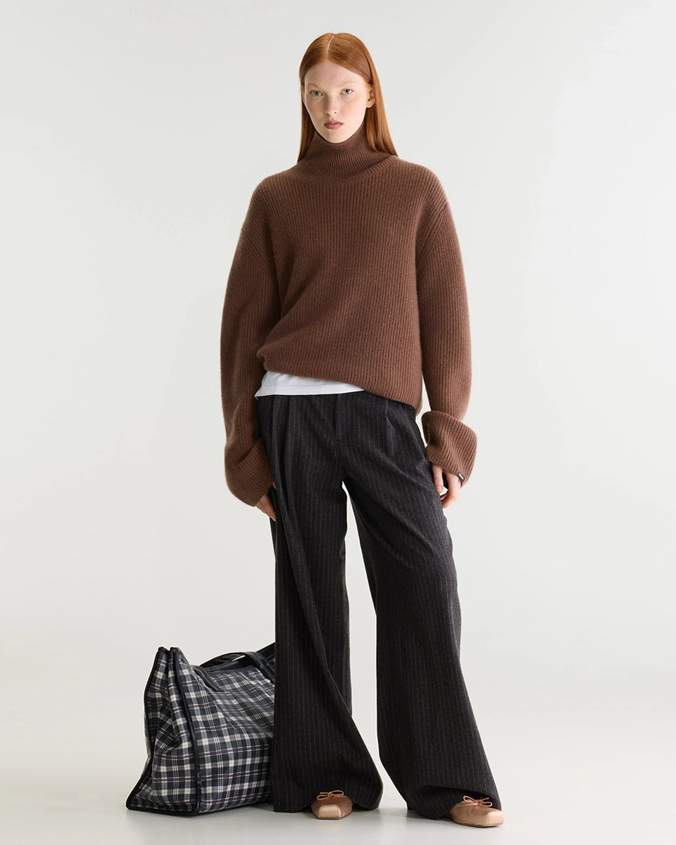 Luźny, brązowy sweter z golfem Synin Tiramisu Bellerose wykonany w 100% z kaszmiru. Posiada proste, szerokie rękawy z wywiniętymi mankietami i kołnierz typu funnel neck. Ma swobodny, lekko luźny krój oraz wyraźną, prążkowaną strukturę materiału. Wysoki, otulający golf dodaje mu szyku i doskonale sprawdza się w chłodniejsze dni, tworząc stylową kompozycję z ciemnymi spodniami.

-Golf

-Długie, szerokie rękawy&nbsp;

-100% kaszmir