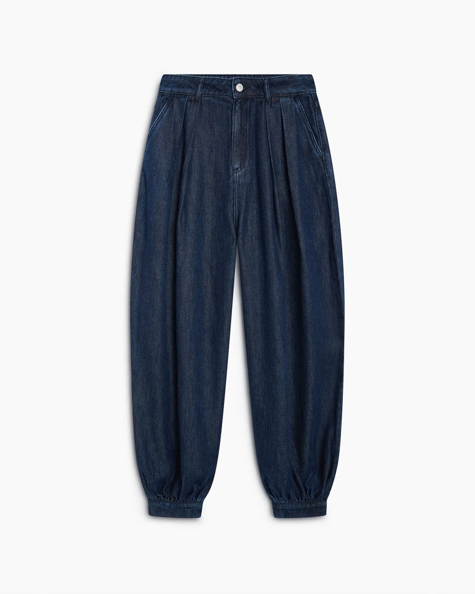 Luźne spodnie typu haremki Tencel TNS Dark Blue Denim z obszernymi nogawkami, które zyskują objętość dzięki zakładkom w talii oraz mankietom u dołu. Mają klasyczne zapięcie na guzik i zamek, kieszenie boczne oraz kieszenie naszywane z tyłu. Całość dopełnia charakterystyczny haft marki na tylnej części pasa. Spodnie są nową interpretacją klasycznego jeansu. Wykonane z wysokiej jakości denimu tencel, pięknie się układają i są lekkie w noszeniu.&nbsp;

-Luźny fason z bufiastymi nogawkami

-Wysokiej jakości den