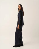 Elegancka, jedwabna peleryna Cata The Garment o asymetrycznym fasonie. Zebrana na lewym ramieniu. Wykończona zmysłową koronką. Wykonana z lejącej, jedwabnej tkaniny.