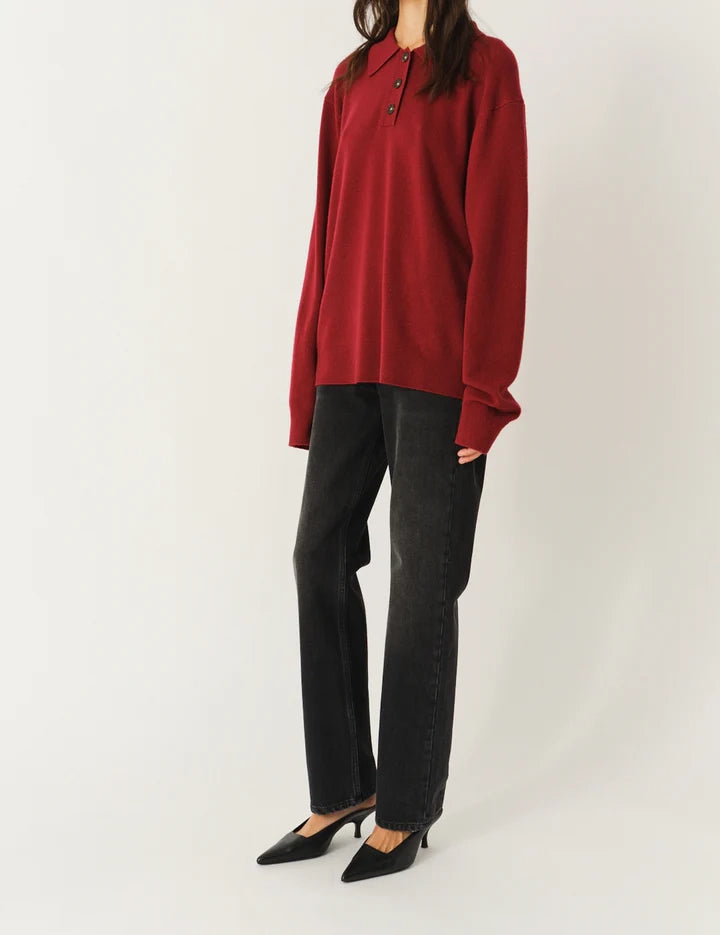 Luźny, długi, czerwony sweter Como Polo z kołnierzykiem i guzikami przy dekolcie. Sweter ma długie, luźne rękawy i wykończony jest ściągaczami. Posiada prosty krój i długość za biodra oraz niewielkie, haftowane logo.