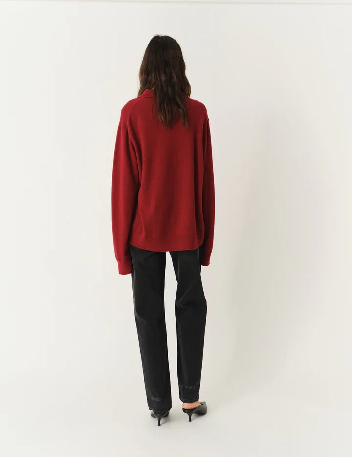 Luźny, długi, czerwony sweter Como Polo z kołnierzykiem i guzikami przy dekolcie. Sweter ma długie, luźne rękawy i wykończony jest ściągaczami. Posiada prosty krój i długość za biodra oraz niewielkie, haftowane logo.