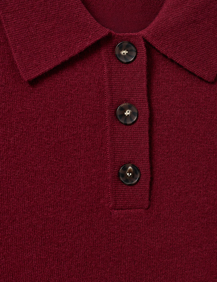 Luźny, długi, czerwony sweter Como Polo z kołnierzykiem i guzikami przy dekolcie. Sweter ma długie, luźne rękawy i wykończony jest ściągaczami. Posiada prosty krój i długość za biodra oraz niewielkie, haftowane logo.