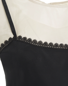 Jedwabna, warstwowa sukienka midi Darling The Garment z okrągłym dekoltem i bez rękawów i z cienkimi ramiączkami. Stworzona z dwóch kontrastowych warstw. Wykończona u dołu piękną koronką. Z tyłu przy szyi wiązana za pomocą cienkich troczków. Na plecach posiada niewielkie wąskie rozcięcie. Sukienka u dołu wykończona jest asymetrycznie. Posiada luźny fason z lekkim wcięciem w talii.