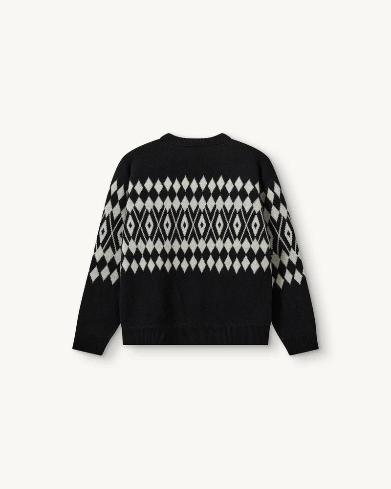 Luźny, wełniany sweter Faroe The Garment w geometryczny, kontrastowy wzór. Posiada okrągły dekolt, opadające ramiona i długie rękawy. Wykończony ściągaczami. Sweter ma prosty krój i długość za biodra. Wykonany z grubej i miękkiej, wełnianej dzianiny z kaszmirem