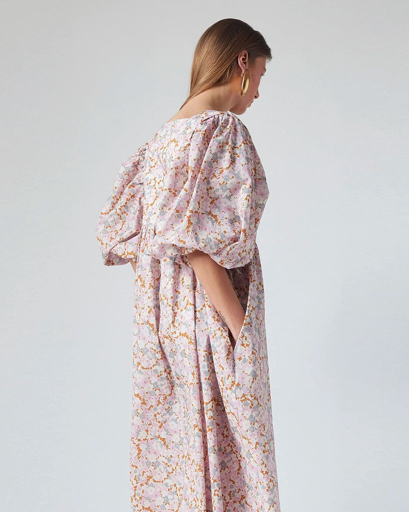 Luźna sukienka maxi Peggy The Label Edition w kwiatowy print z krótkimi, bufiastymi rękawami. Posiada kwadratowy dekolt oraz dwie, boczne kieszenie. Jest odcięta pod biustem. 